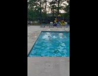 Girl in bikini jumps in the pool then floats