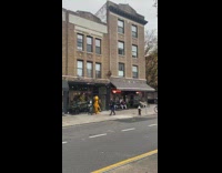 Person wears lobster mascot costume outside restaurant 