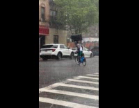 Guy rides bike balance tv on head