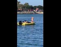 Blonde girl colorful pants front yellow boat