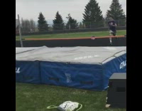 Guy does front flip over orange bar 