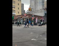 Collab WINY - Man black jacket ride bike raise leg tire on head UPS Store