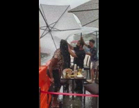 Restaurant employees try to fix umbrellas rain