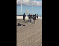 Couple does airplane pose in busy walkway 