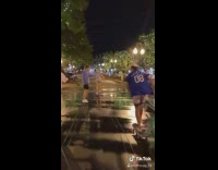 Six guys friends skateboard down street night