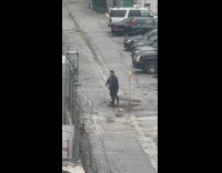 Man in black outfit dances with a skull nearby
