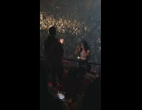 Man takes video of woman on the concert balcony