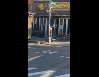 Guy and girl walk pet white duck down sidewalk 