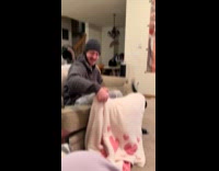 Man playfully pokes dog underneath blanket