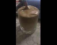 Stirring whipped cream in dalgona coffee