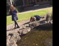 girl in blue school uniform falls on rocks