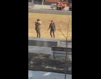 Woman at park walking a rabbit on a leash 
