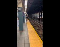 Man rides bicycle down train platform