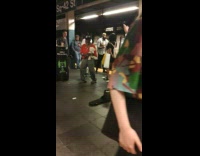 Man holding white teddy bear dances to bass guitar music in subway station