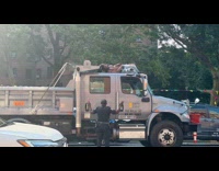 Man on top truck refuse going down