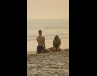 Woman black swimsuit hold boots kneel sand