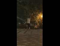 Guy spins large cube park black shorts 