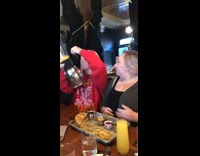 Woman drinks directly from beer bong at lunch