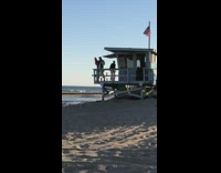 Man in jersey poses at the lifeguard house