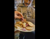 Little boy pretends to serve charcuterie plate 