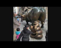 Dad and kids look at poop statue 