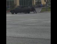 Collab risksIG - Guy on rollerblades holds onto back of black pick up truck and does donuts 
