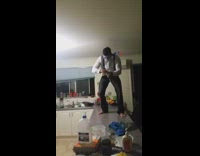 Guy on kitchen countertop in scuba diving mask opens two beer bottles and falls off counter
