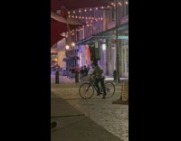 Man carries trashcan on head on bike