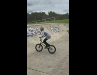 Kid does back flip on bmx bike at skate park and lands on his face hard in bowl