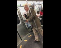 Man brown suit sings loudly and dances to music on speakers on subway train