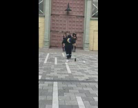 Two women black outfit boots dance sidewalk 