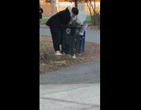 Woman picks through trash can at the park 