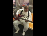 Guy plays bass guitar and sings to subway passengers