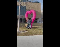 Two kids stand on dad pink heart
