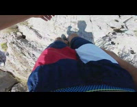Blue shorts guy jumps cliff ocean underwater