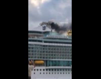 Cruise ship releasing black smoke as it sails 