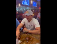 Man flicking bean out from drink