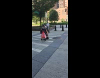 Couple rides mobility scooter cross the street