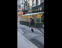 Man carries two kettlebells while dragging weights 