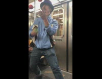 Man blue jacket juggles balls on subway train