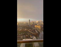 Rain Downpour Over City Sunset and Rainbow