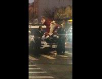 Santa sits on NYPD car and dances  