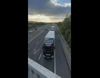 Guy spots trucks by the bridge above the freeway