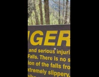 Blue jacket guy brown danger sign river