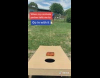 Girl does corn hole game tricks