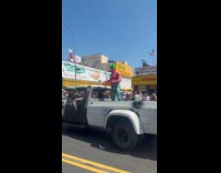 Man wearing mermaid pants breathing fire at parade 