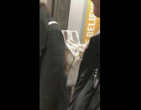 Woman with doll legs sticking outside of clear backpack on subway train