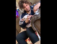 Guy in blue adidas jacket holding white dog and it coughs in his face 