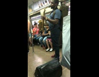 Guy green backpack playing saxophone on subway train