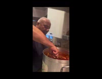 Man cooks and son tries to dip bread 